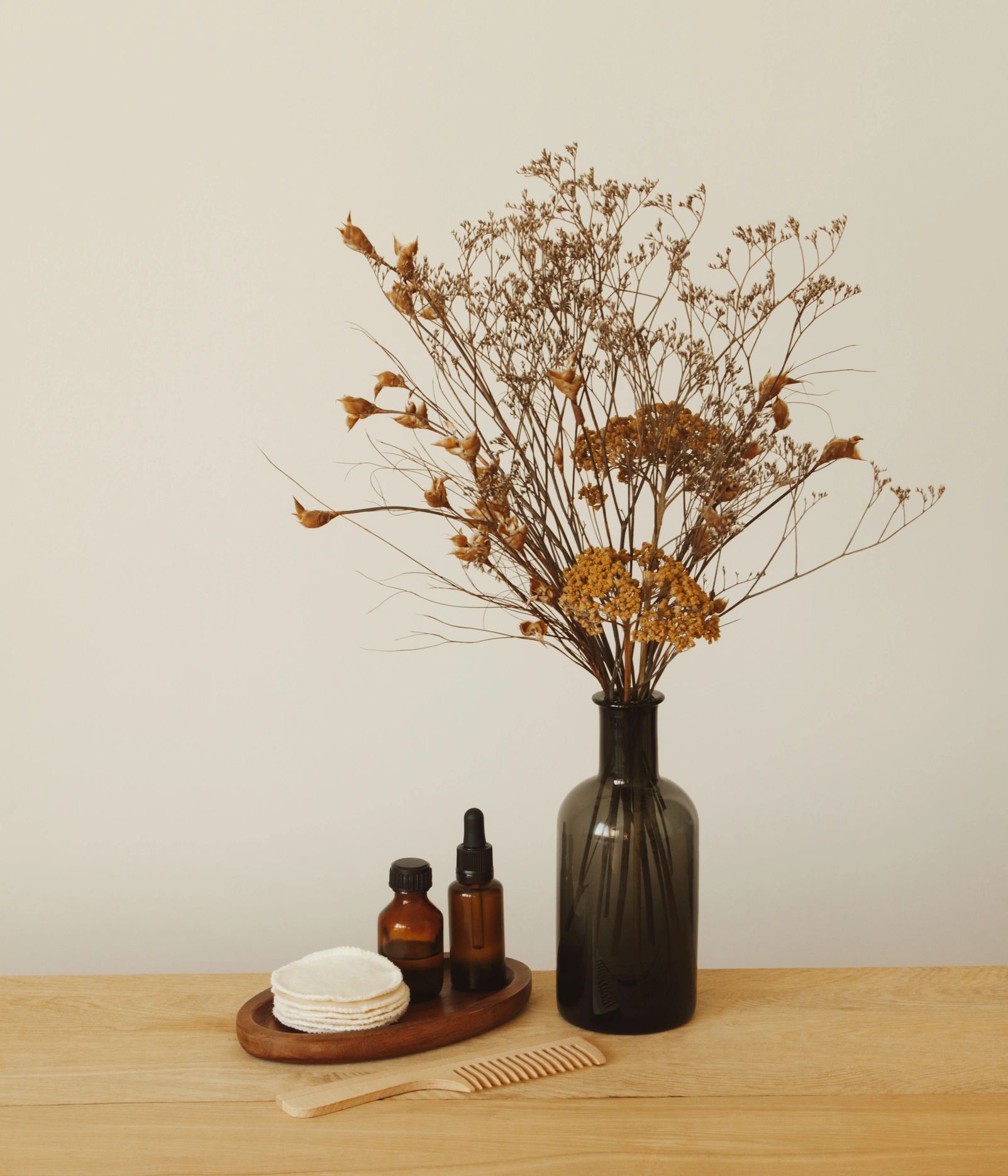 Set of beauty products and toiletries and vase with flowers