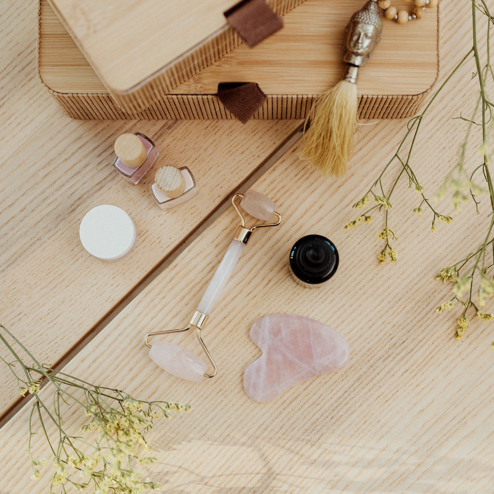 Premium skincare product flatlay with facial oil and beauty tools